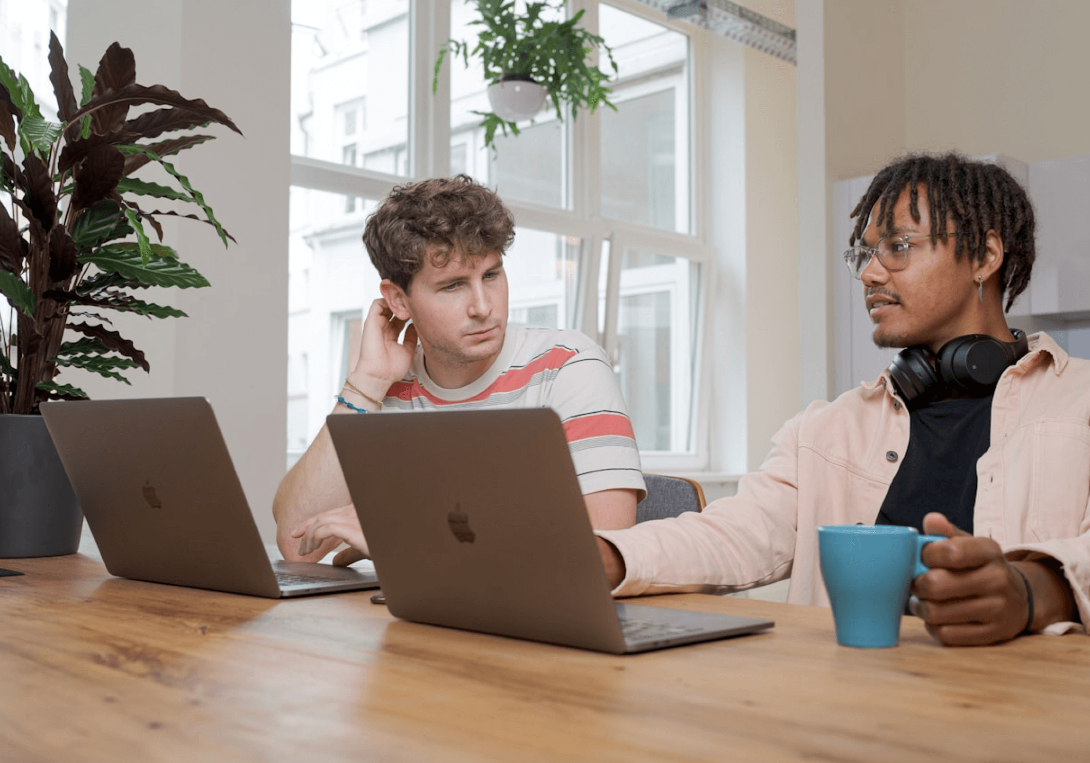 Two people sitting on a table with their laptop planning for the website design & development.